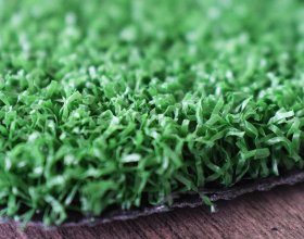 Dense tennis artificial turf fibers for consistent court performance