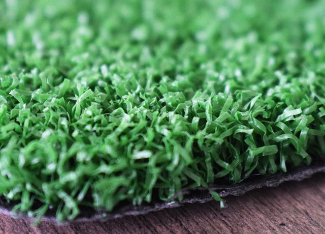 Dense tennis artificial turf fibers for consistent court performance