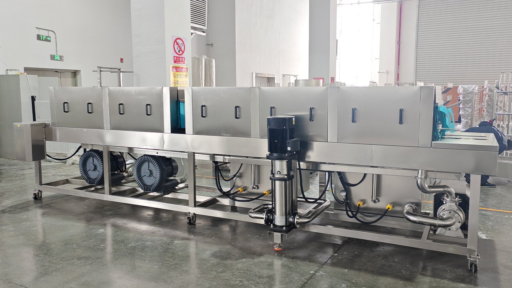 Tunnel-type crate washing machine cleaning seafood crates and fish boxes in a processing plant